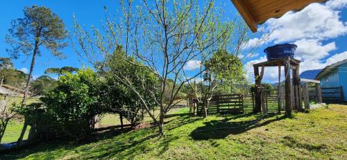 a wooden fence and a water tower in a field at Casa Pessegueiro in Urubici
