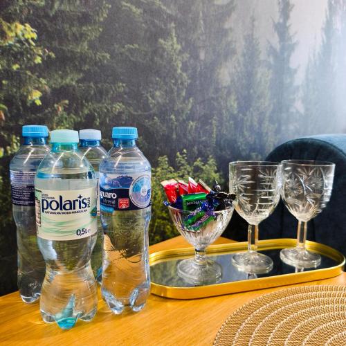 a tray with bottles of water and glasses on a table at Apartament Ustroń 20 in Ustroń