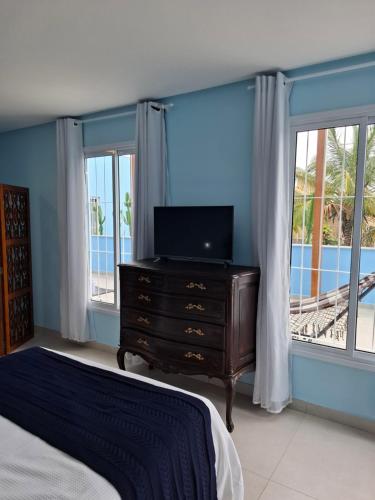 a bedroom with a bed and a dresser with a television at Quinta da Praia in Serra