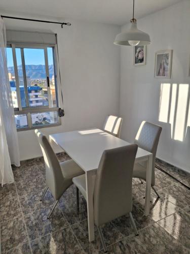 a white dining room table with chairs and a window at Sea and Sun con vistas a la playa San Antoni in Cullera