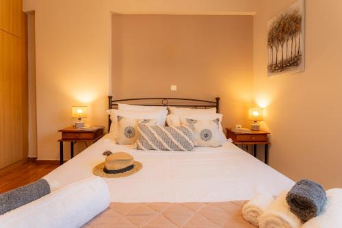 Un dormitorio con una gran cama blanca con toallas. en The Mirror Apartment, en Mytilini