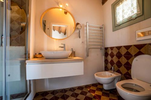 a bathroom with a sink and a toilet and a mirror at Loft con terrazzo sulla Scala in Caltagirone