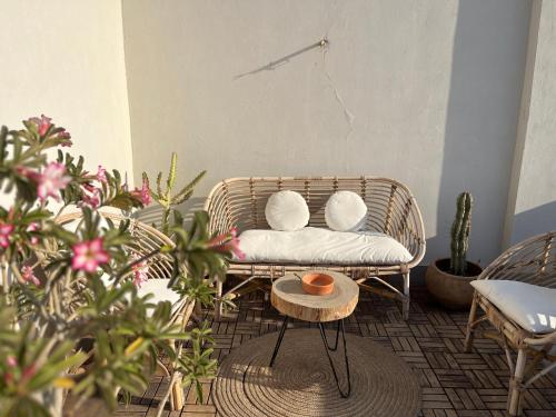 a rattan chair with two pillows and a table at Modern chic rooftop studio in Sheikh Zayed