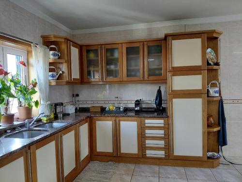 Una cocina con gabinetes de madera y un fregadero. en S. Miguel, en Arouca