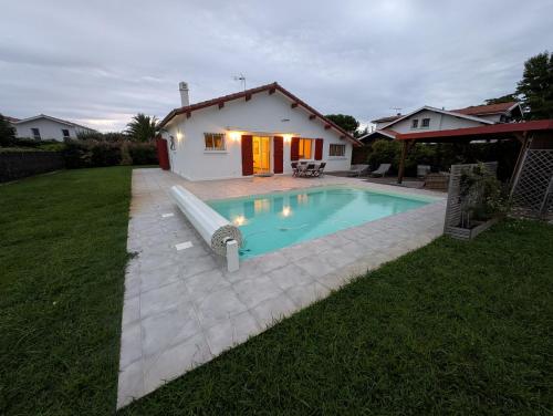 a swimming pool in a yard with a house at Landaise in Messanges