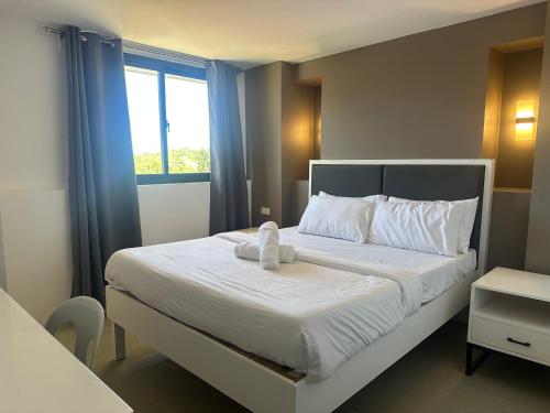a bedroom with a bed with a stuffed animal on it at D'ELEMENTS HOTEL AND DORMITORY in Laoag