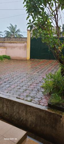 a brick walkway with a fence and a wall at Appartement haut standing Mimboman in Yaoundé