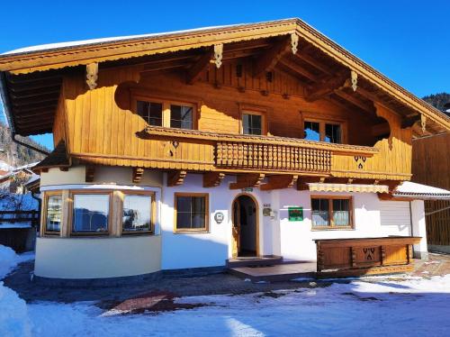 a house with a wooden roof in the snow at Ferienhaus Schlössl Wildschönau WILD446 in Dorf