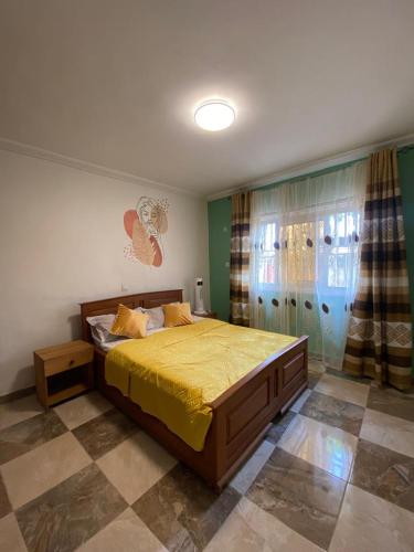 a bedroom with a bed with a yellow bedspread at Appartement haut standing Mimboman in Yaoundé