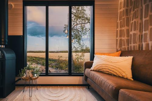 a couch in a room with a large window at Piilotupa in Inari