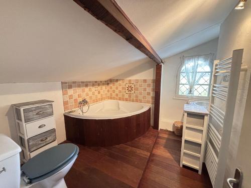 a bathroom with a tub and a toilet and a sink at Maison de vacances, Piscine & Plage à pied in La Teste-de-Buch
