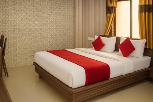 a bedroom with a large bed with red pillows at The Sky Comfort - Hotel The Heaven, Dwarka in Dwarka