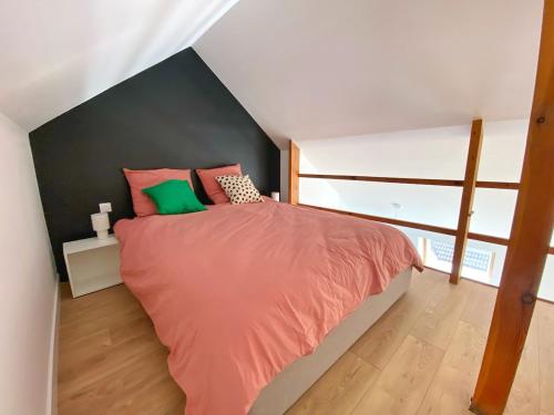 1 dormitorio con 1 cama con almohadas rosas y verdes en Le Zen Kyoto, en Lambersart