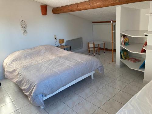 une chambre avec un grand lit et une table dans l'établissement Maison proche Vaison la Romaine, à Saint-Romain-en-Viennois