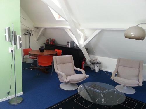 uma sala de estar com duas cadeiras e uma mesa em Appartement Sint Jan em Den Bosch