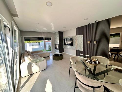 una sala de estar con un sofá y una mesa en MoradiaT4 com piscina aquecida, en Arrentela