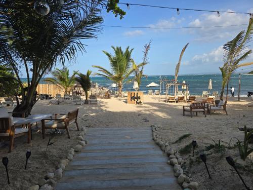 a sandy beach with tables and benches and the ocean at Sunset Apartment Beach Residences Steps from the Beach in Puerto Plata
