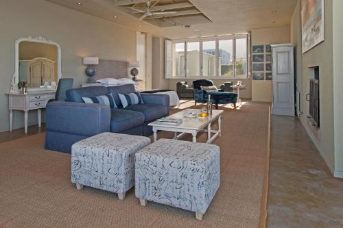a living room with a blue couch and a table at Mosselberg on Grotto Beach in Hermanus
