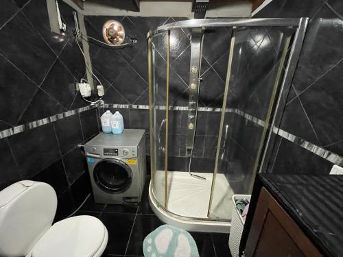 um banheiro com chuveiro e máquina de lavar em Departamento Amplio a cercanías del Rio em Posadas