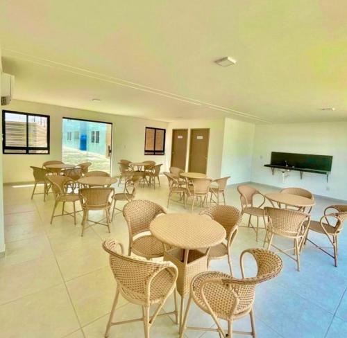 una habitación con mesas, sillas y un piano en Apartamento 303, en João Pessoa