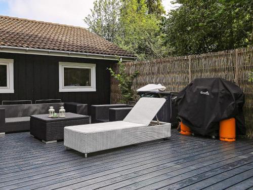a patio with a chair and a table and a fence at 8 person holiday home in Vejby in Vejby