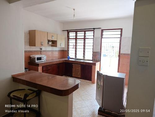 une cuisine avec des armoires en bois et un comptoir dans l'établissement 4 bedroom apartment in Nyali, à Mombasa