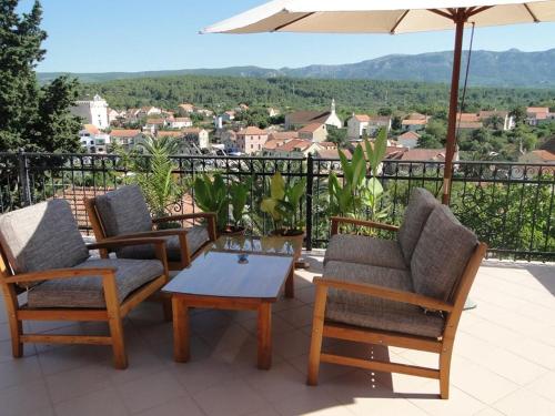 a patio with chairs and a table and an umbrella at Villa Agava in Vrboska