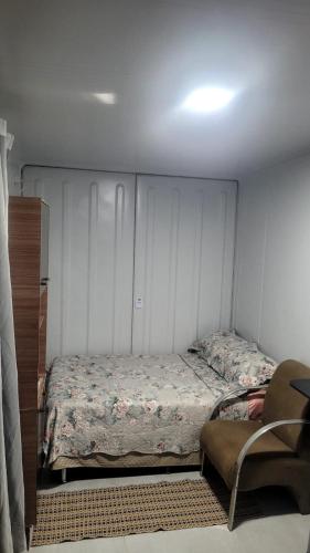 a small bedroom with a bed and a chair at Refugio Stella Container - Aconchegante, Completo e Bem Localizado in Brotas