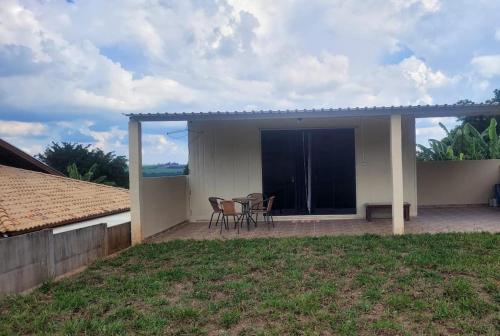 a house with a patio with two chairs and a table at Kitnet Container - Prática e aconchegante in Brotas