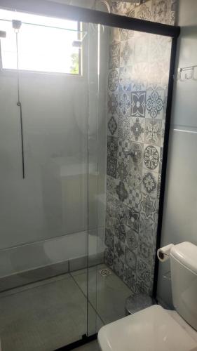 a bathroom with a glass shower and a toilet at Refugio Stella Container - Aconchegante, Completo e Bem Localizado in Brotas