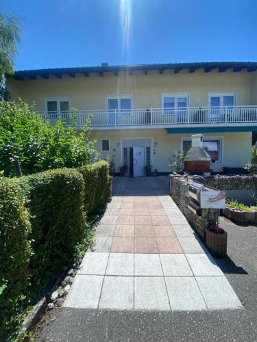 a house with a walkway in front of it at Studio Cleo - ein Raum - Dusche und WC extern am Flur in Pörtschach am Wörthersee
