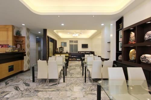 restauracja z białymi krzesłami i jadalnią w obiekcie 陶陶居商旅 Tautauchu Hotel w mieście Hualian