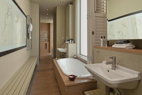 a white bathroom with a tub and a sink at Mosselberg on Grotto Beach in Hermanus
