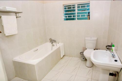 ein Badezimmer mit Badewanne, Toilette und Waschbecken in der Unterkunft Sunrise Serenity Lux Homes in Lilongwe