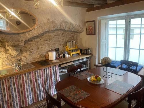 a kitchen with a table and a stone wall at Bishop's Residence in Tallinn