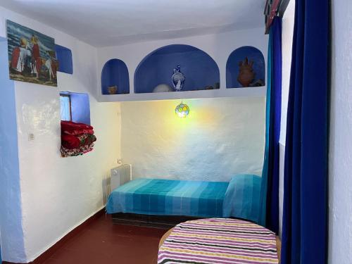 a bedroom with blue and white walls and a bed at Dar Onsar in Chefchaouene
