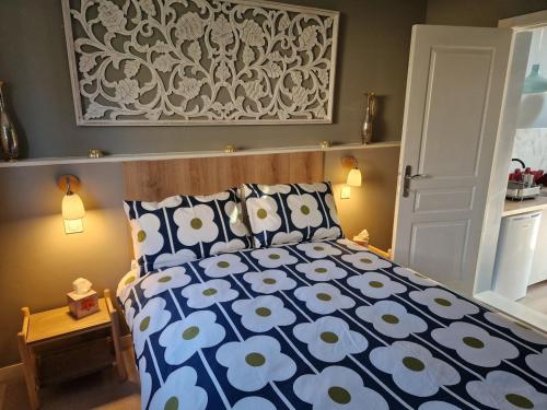 Le ChalardにあるCozy small houseのベッドルーム1室(青と白の掛け布団付きのベッド1台付)