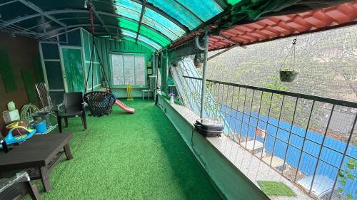 a house with a swimming pool and a balcony with green grass at Row House Near US Consulate BKC & NMCC in Mumbai