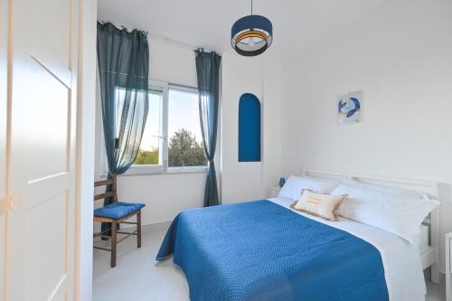 a bedroom with a blue bed and a chair at Terrazza Ammirati in Ischia