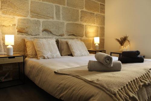 a bedroom with a large bed with a stone wall at Cozy Air-Conditioned - Central - Close to Train Station in Brive-la-Gaillarde