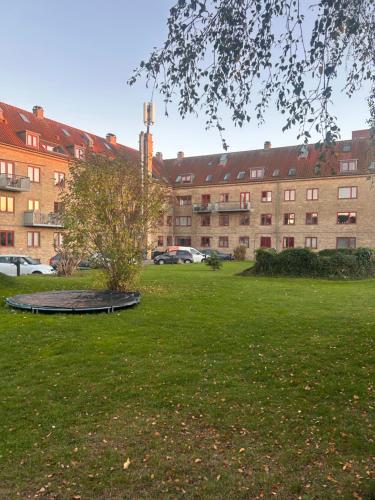 a park with a tree in the middle of a building at Close to city center in Rødovre