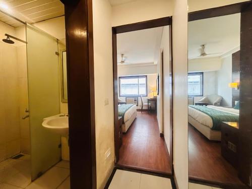 a bathroom with two beds and a sink and a mirror at Hotel Park Prime With Primmum Rooms in Haridwār