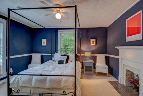 1 dormitorio azul con 1 cama y chimenea en Historic McGuire House, en Todd