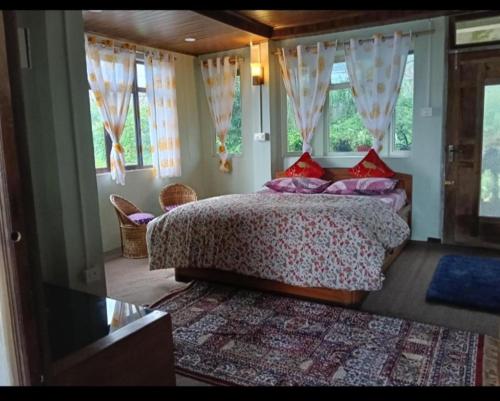a bedroom with a bed in a room with windows at Grace Homestay in Darjeeling