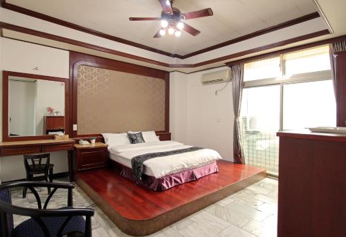 a bedroom with a bed and a desk and a mirror at 陶陶居商旅 Tautauchu Hotel in Hualien City