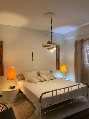 a bedroom with a large bed with two lamps at Mindelo Urban Apartment in Mindelo