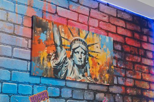 a painting of the statue of liberty on a brick wall at Hoboken Hideaway - Walk to Transit - 15 Mins to NYC in Hoboken