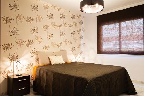 a bedroom with a bed and a wall with flowers at Suncity Flat Salitre II in Málaga