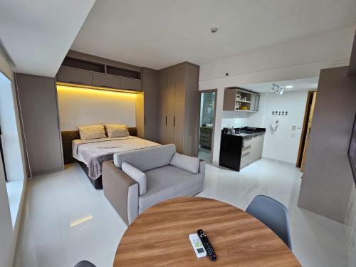 a bedroom with a bed and a table in a room at Tropical Executive Flat in Manaus