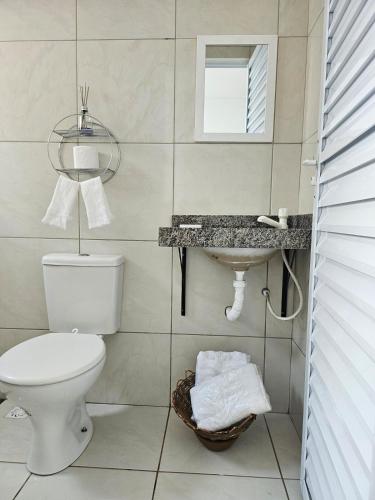 a bathroom with a toilet and a sink at Casa inteira próximo ao Cumbuco e Fortaleza in Caucaia